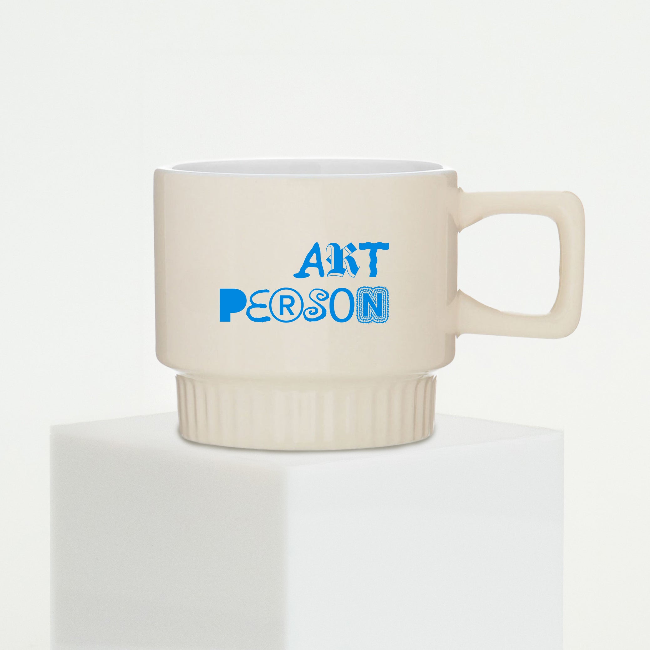 Beige mug with blue text 'ART PERSON' on a white background