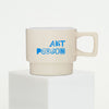 Beige mug with blue text 'ART PERSON' on a white background