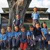 Group of smiling school children in front of their school house in Darjeeling, India.