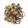 Pile of Darjeeling first flush tea to show wiry black, brown and green tea leaves.