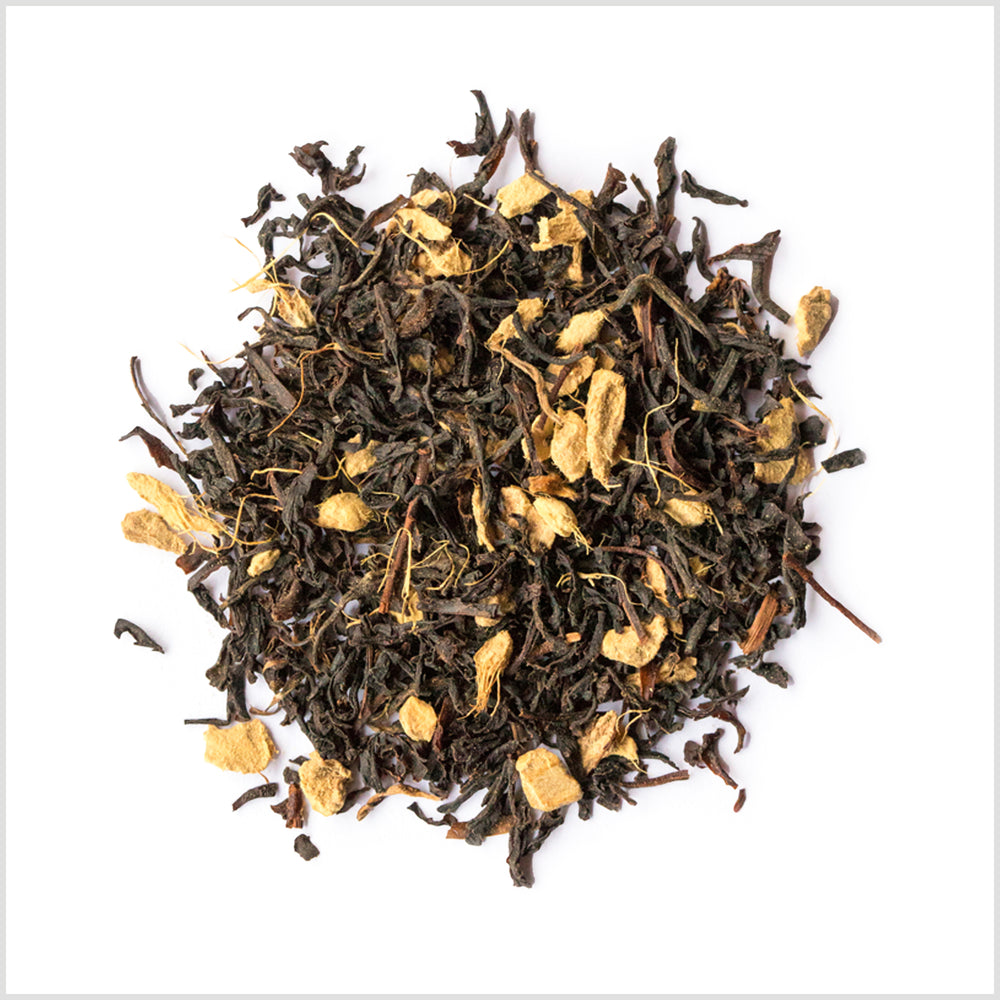 Circular pile of full leaf black tea with ginger pieces.