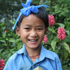 Schoolgirl with a big smile wearing her bright blue school uniform.