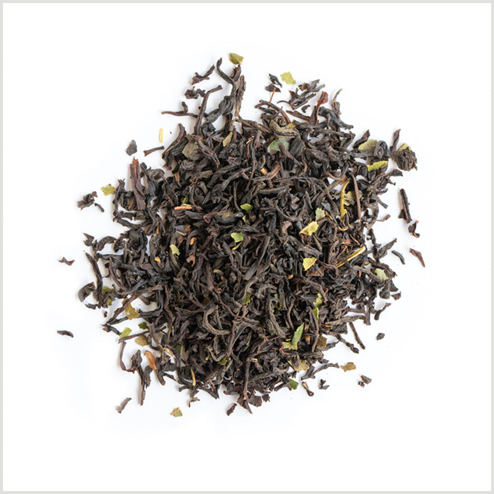Pile of loose leaf black tea showing ingredient detail including light green lemon myrtle.