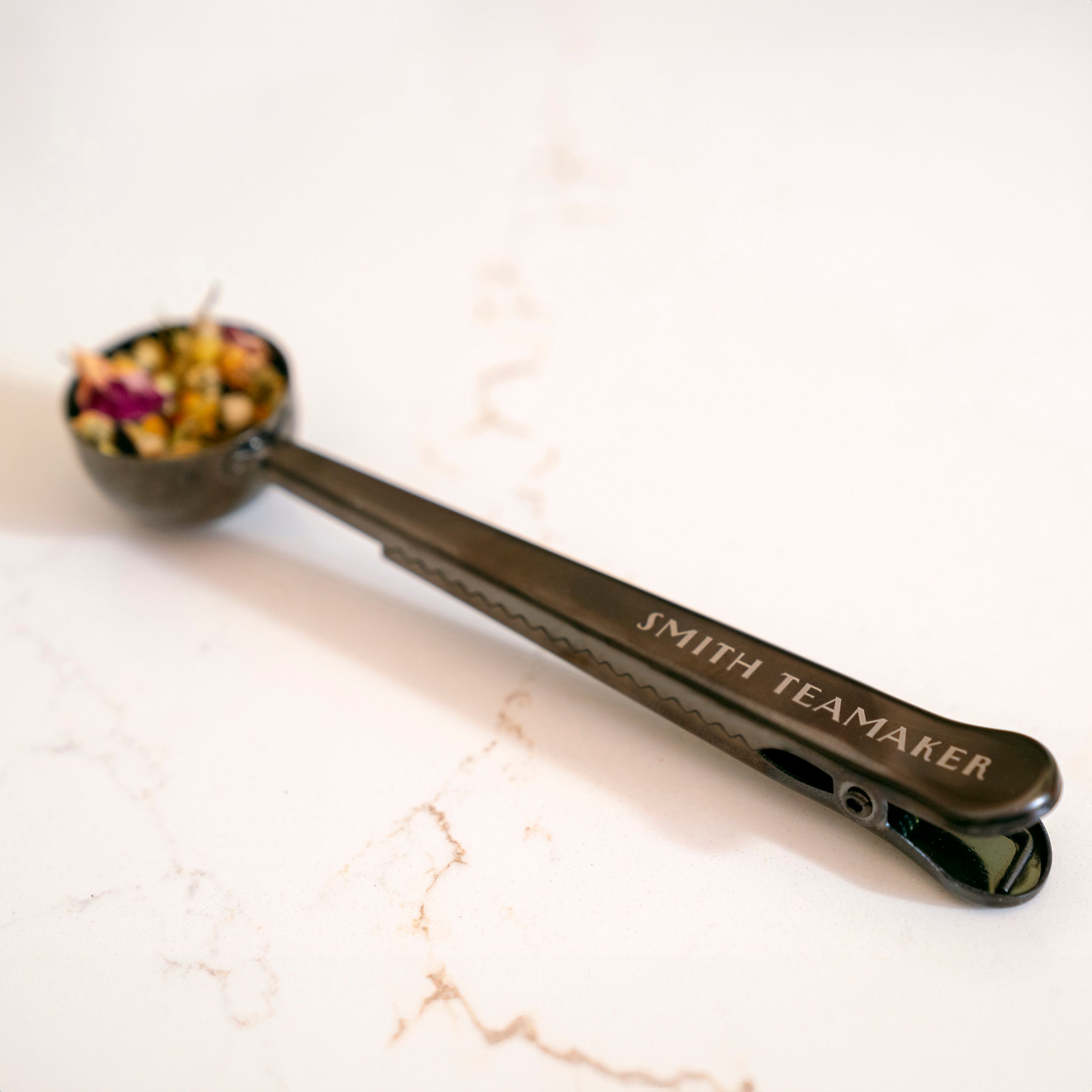 Up close detail of loose tea scoop with Smith Teamaker logo.