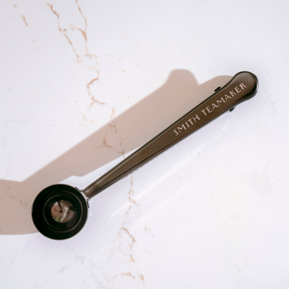Loose tea scoop with Smith Teamaker logo on marble background.