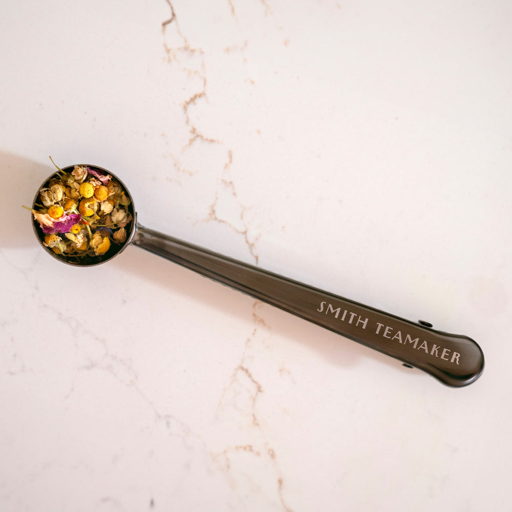 Loose tea scoop with Smith Teamaker logo and scoop filled with tea.