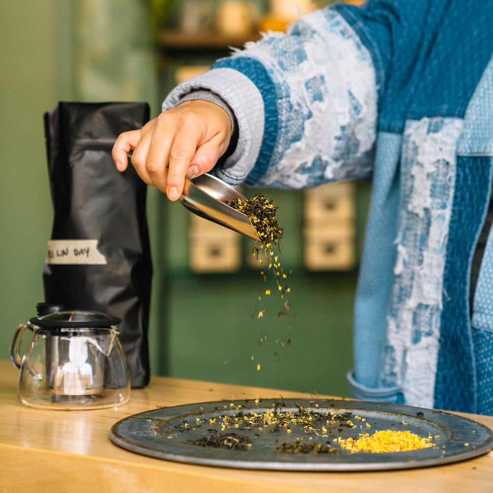 Chef Mei Lin holding silver tea scoop.