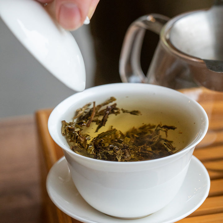 Gaiwan filled with loose tea and water.