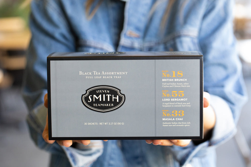 Person holding grey box with black trim.