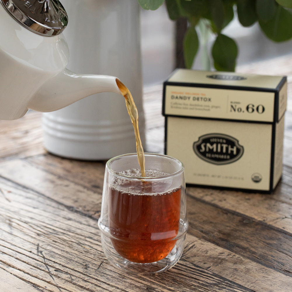 Teapot pouring into a glass cup.