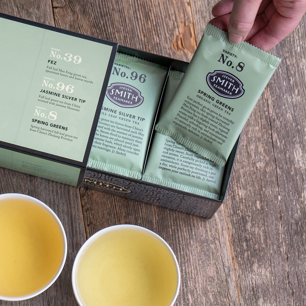 Green box with black trim on wooden table.