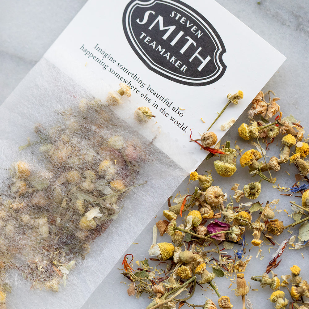 White paper filter with black Smith logo shield filled with chamomile petals.