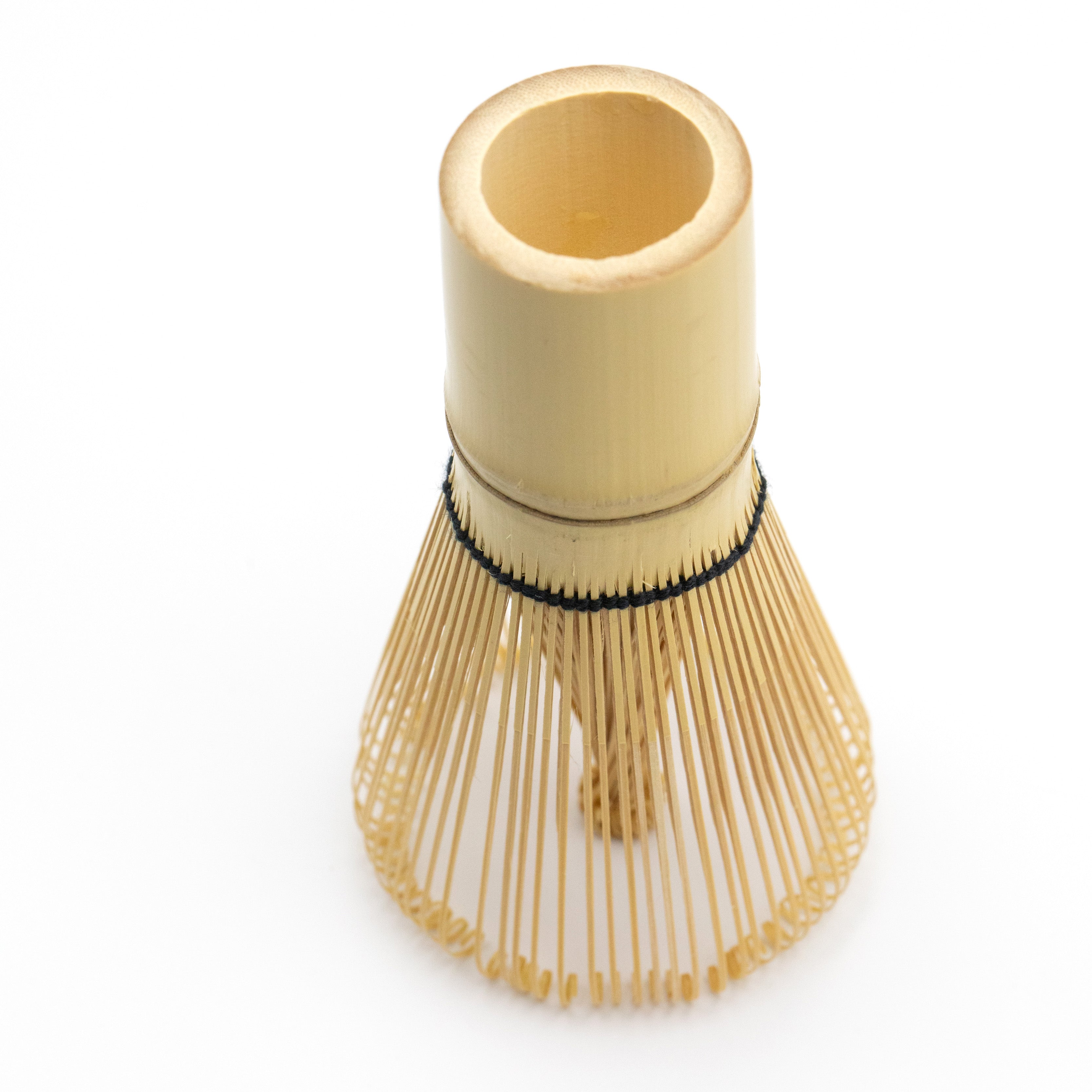 Bamboo matcha whisk with black thread.