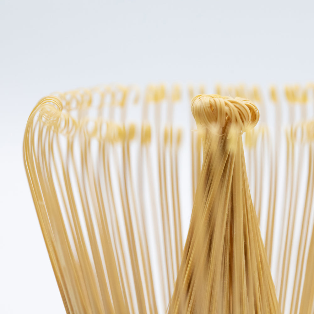Bamboo matcha whisk with black thread.