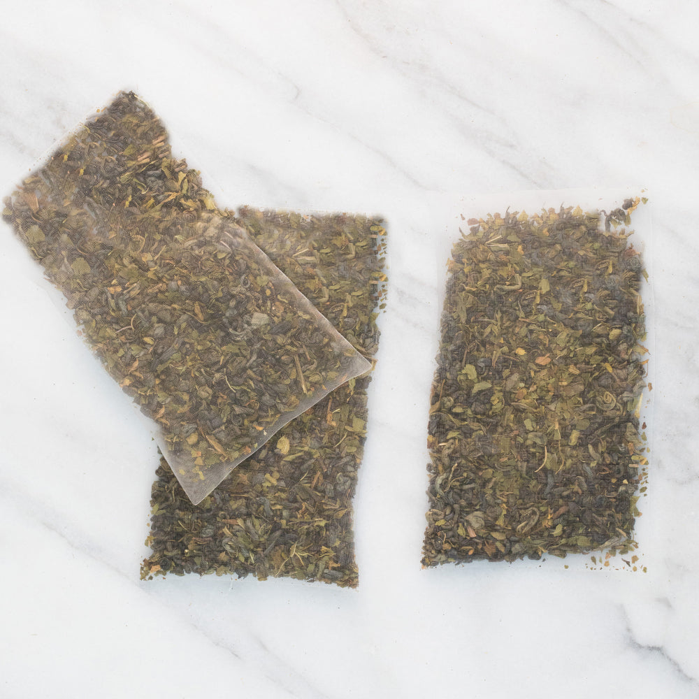 Three sachets filled with Mediterranean Mint iced tea on marble background.