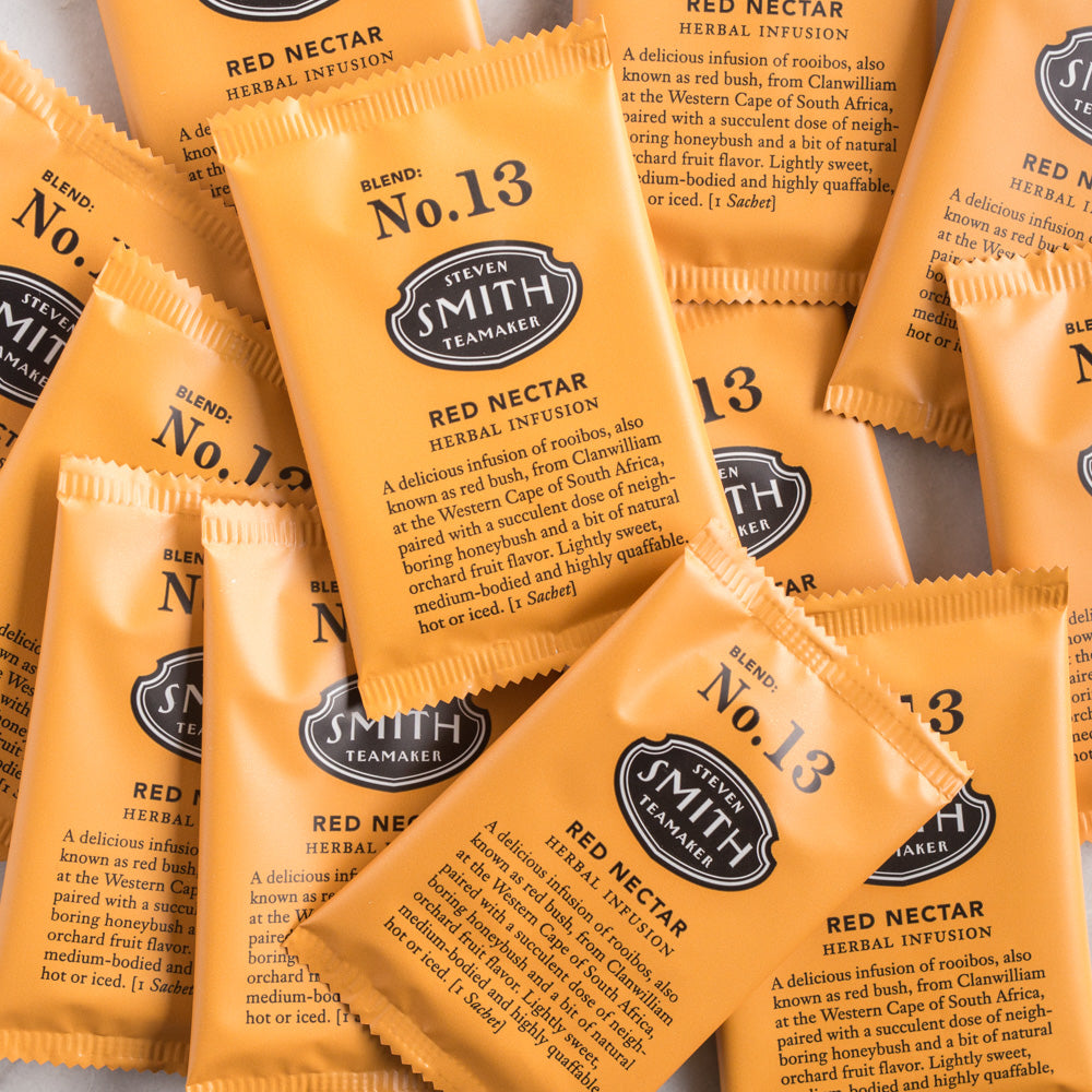 A pile of overwrapped sachets of Red Nectar herbal tea.