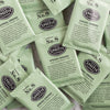 A pile of overwrapped sachets of Spring Greens green tea.